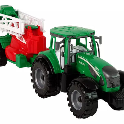 Žalias ūkinis traktorius su raudonu ir žaliu purkštuvu, varomas frikciniu būdu