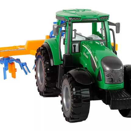 Žalias traktorius su oranžiniu ir mėlynu grėbliu, varomas trintimi