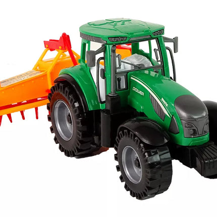 Žalias traktorius su oranžiniu kultivatoriumi vaikams