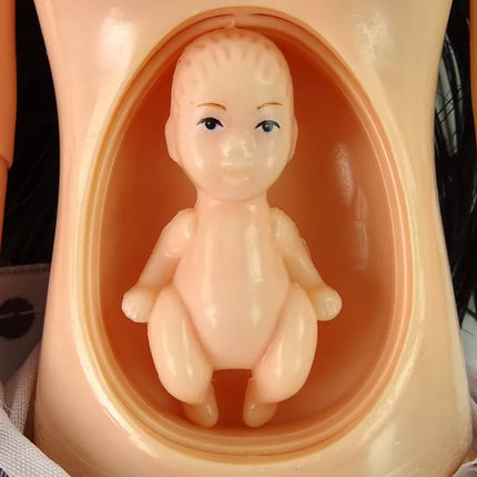 Lėlė nėščia su kūdikiu, vilkinti balta suknele