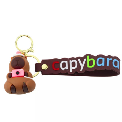 Raktų pakabukas su kapibaros figūrėle, kameros ir kepurės pakabuku bei karabino žiedu
