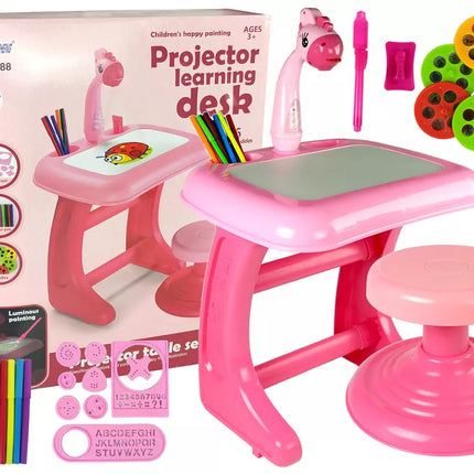 Braižymo stalas, kėdė, projektorius, rožiniai rašikliai, paveikslai